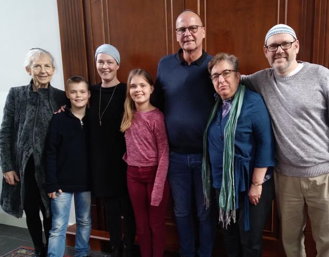 Family of four converting to Judaism, flanked by rabbis