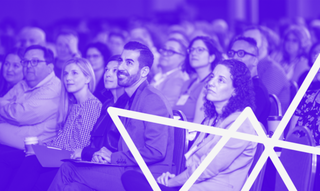 A crowd seated in an auditorium with the edge of a Jewish star superimposed.